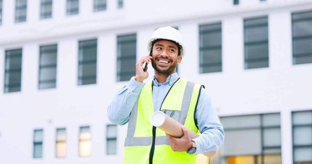 Man smiling on the phone | Featured image for the Office Fitout Company Home Page for Tribella Group.