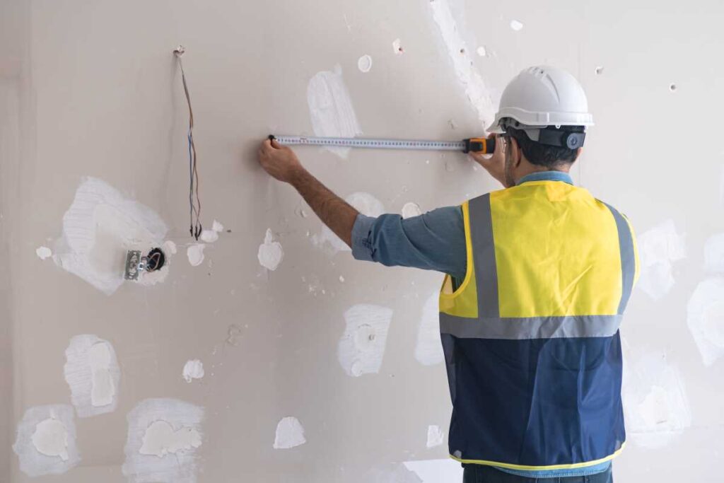 Contractor repairing plasterboard | Featured image for the Home Repair Services Page for Tribella Group.